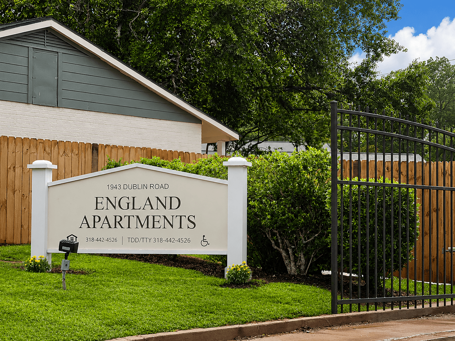 A sign for England Apartments is in front of a building.